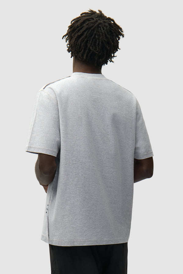 Reversible label T-shirt in Grey worn by a model, half-body back view