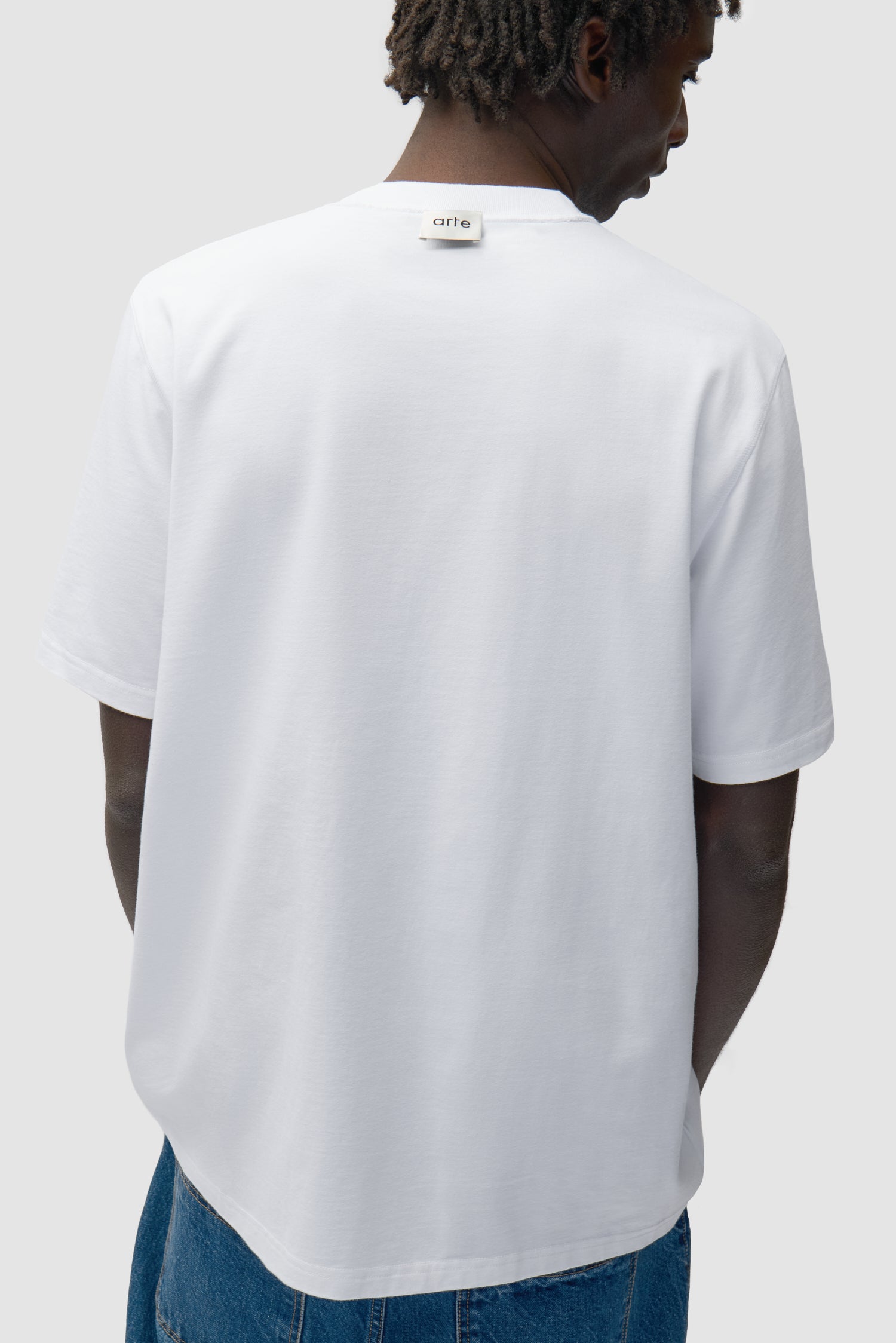 Vue détaillée du t-shirt à étiquette réversible en blanc, montrant l'étiquette inversée.