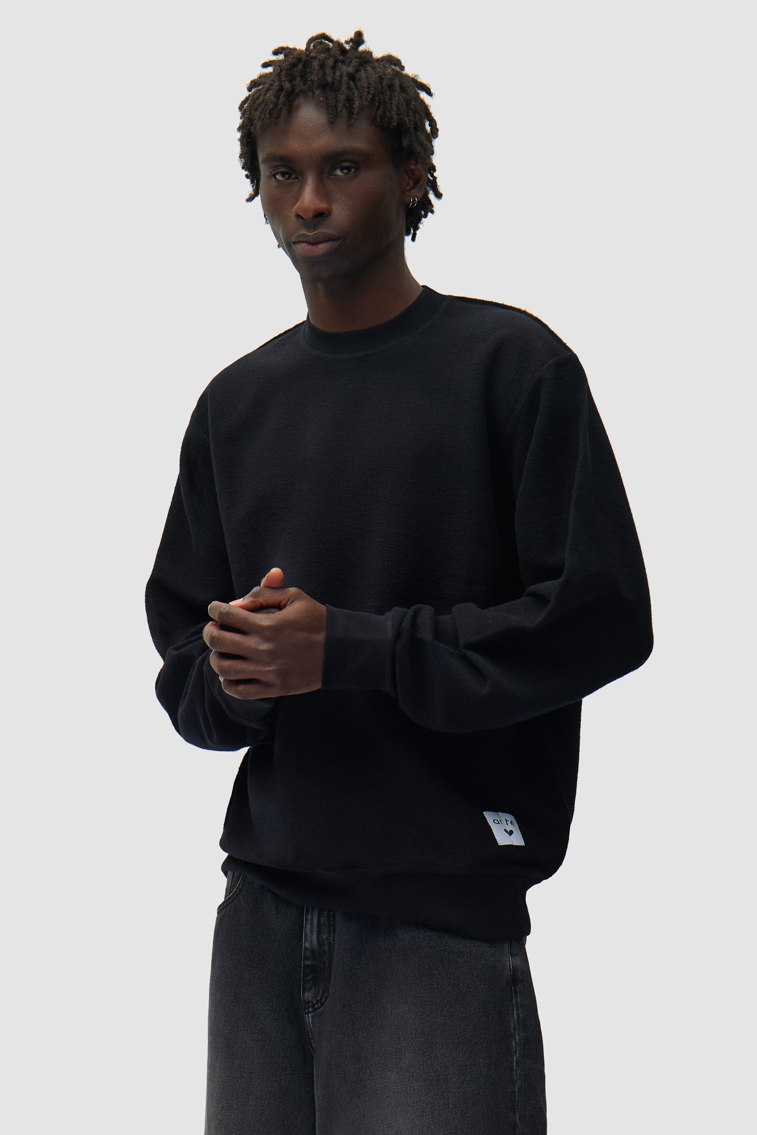 Étiquette réversible Sweat à col rond noir porté par un mannequin, vue de face en demi-corps