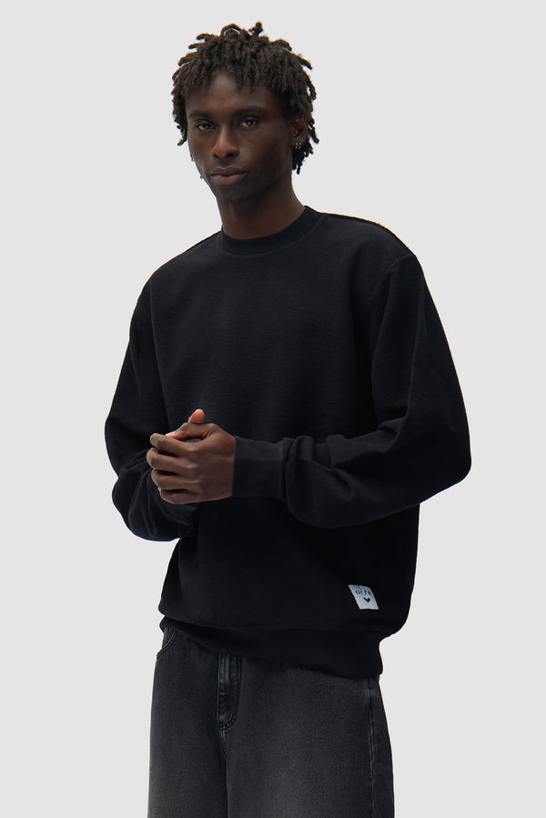 Reversible label Crewneck in Black worn by a model, half-body front view