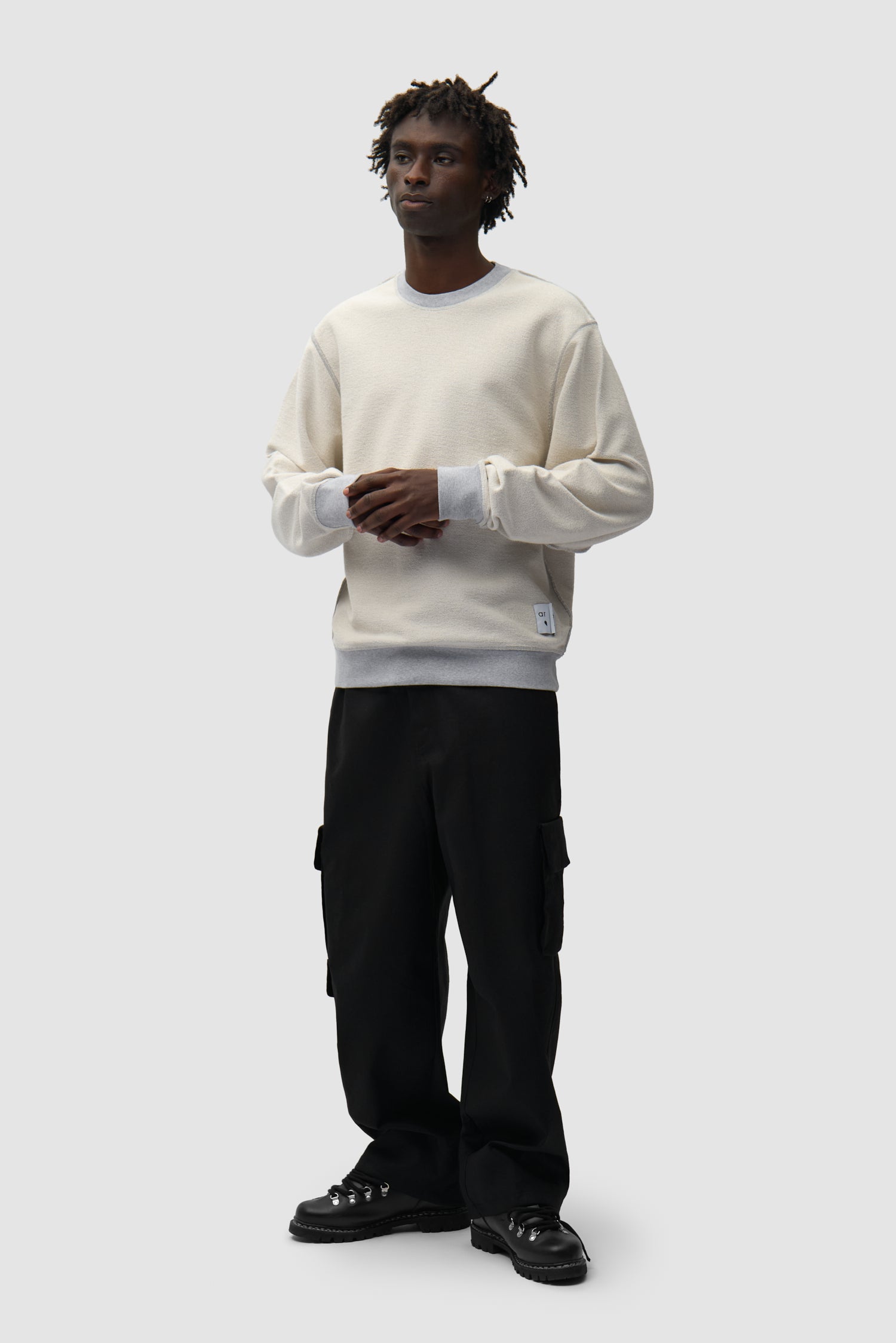 Étiquette réversible Sweat à col rond gris inversé porté par un mannequin, vue de face en pied