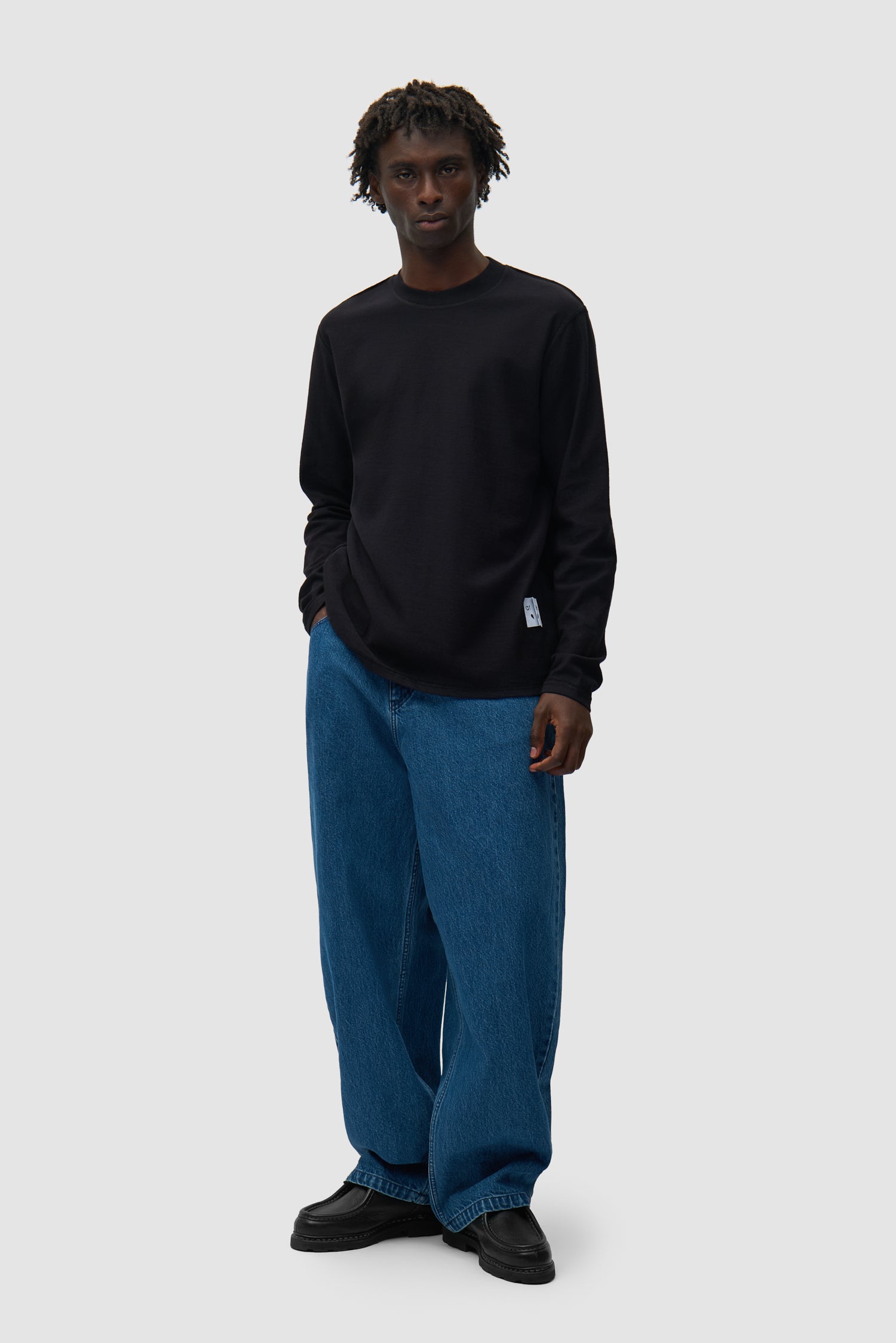 T-shirt à manches longues réversible noir porté par un mannequin, vue de face en pied