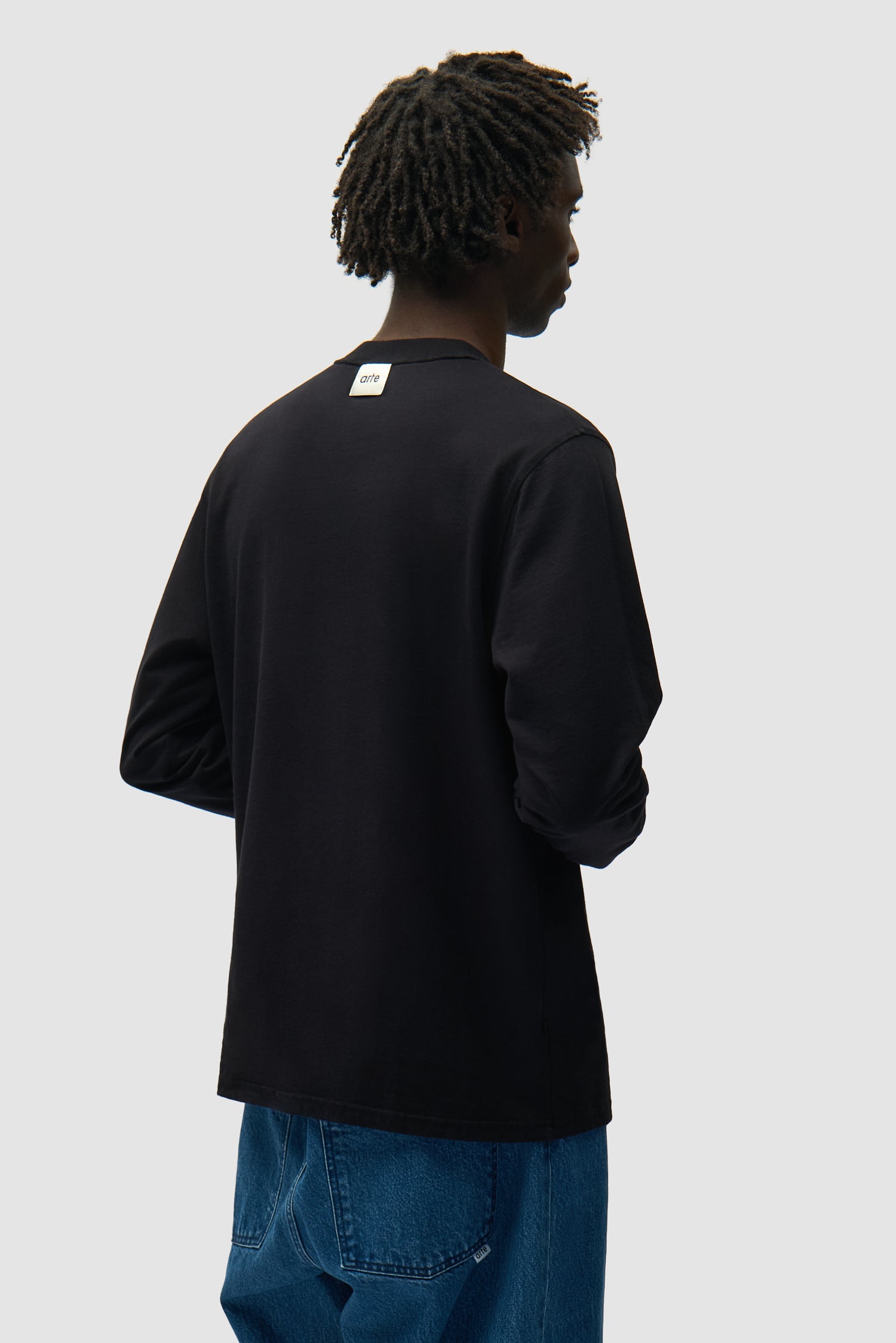 T-shirt à manches longues réversible noir porté par un mannequin, vue de dos à mi-corps