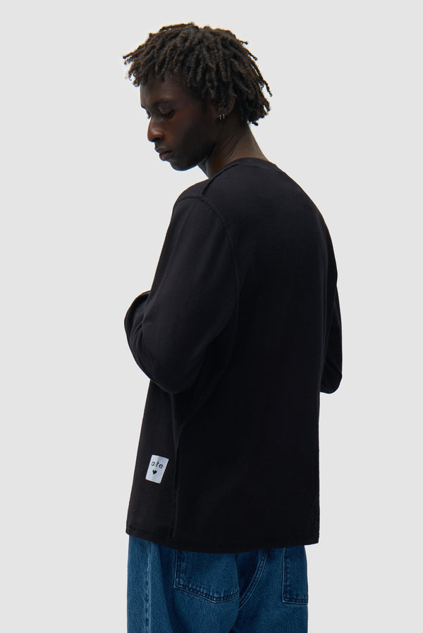 Reversible label Longsleeve in Black worn by a model, half-body side view