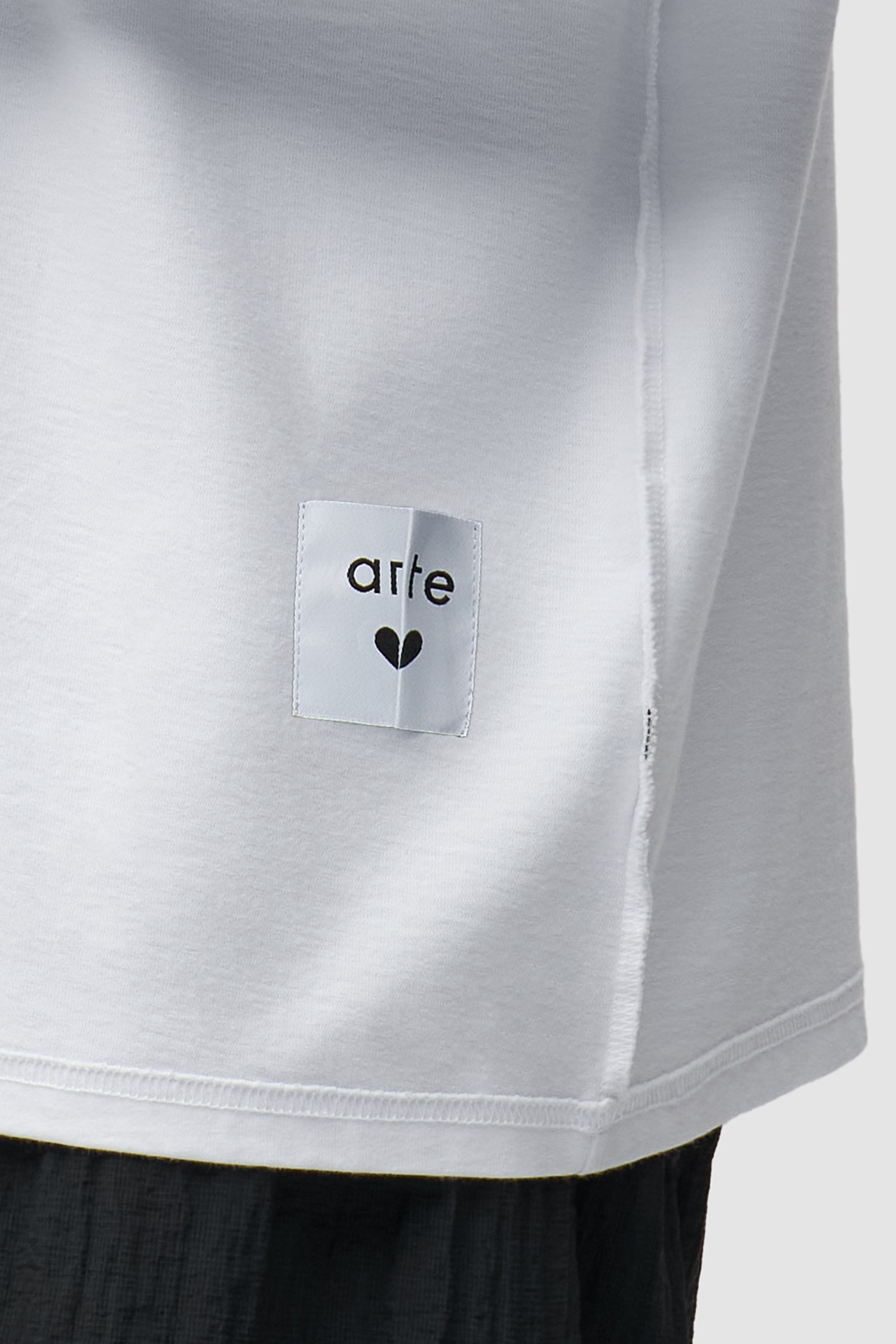 Vue détaillée du t-shirt à manches longues réversible blanc, avec logo sur le devant