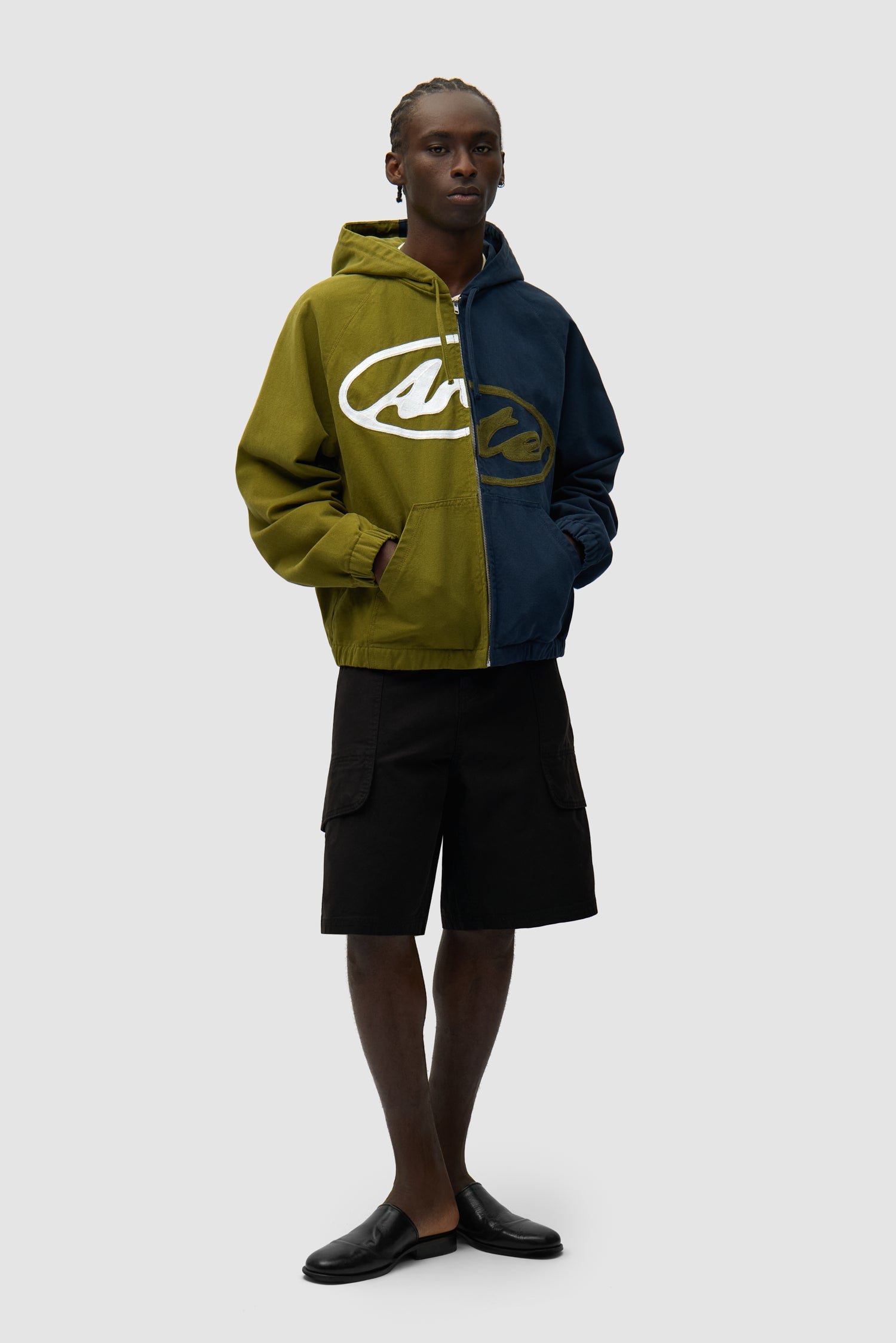 Veste à capuche en toile avec logo divisé, bleu marine/vert, portée par un mannequin, vue de face en pied