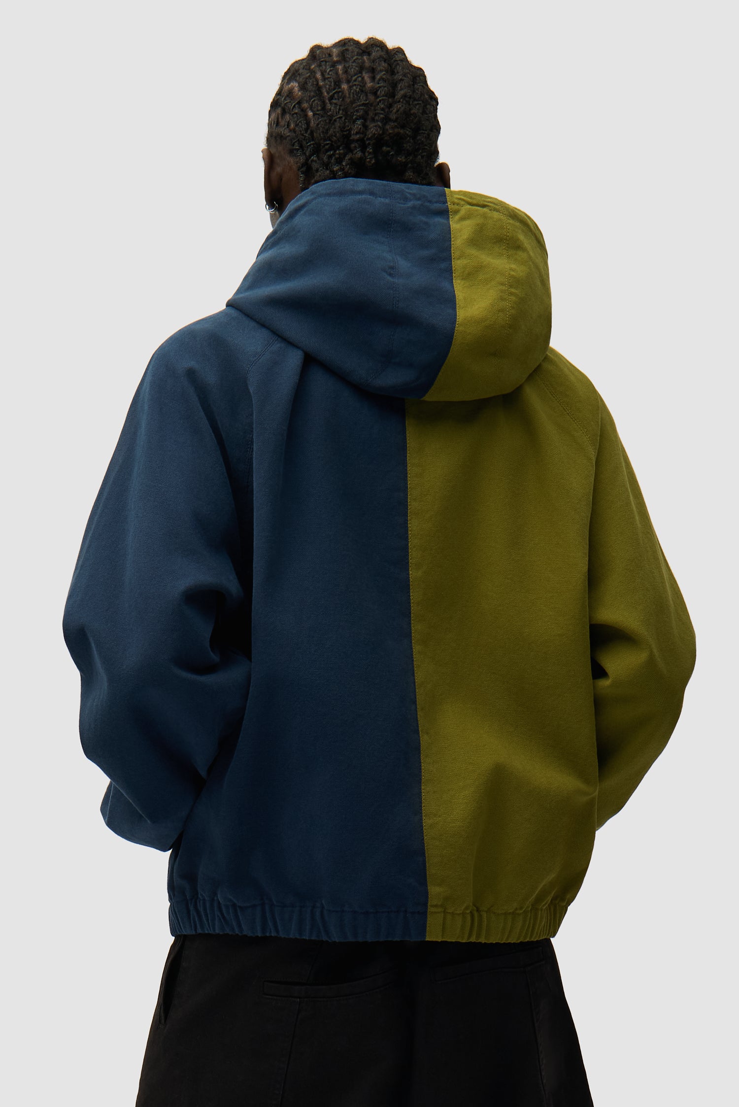 Veste à capuche en toile avec logo divisé, bleu marine/vert, portée par un mannequin, vue de dos à mi-corps