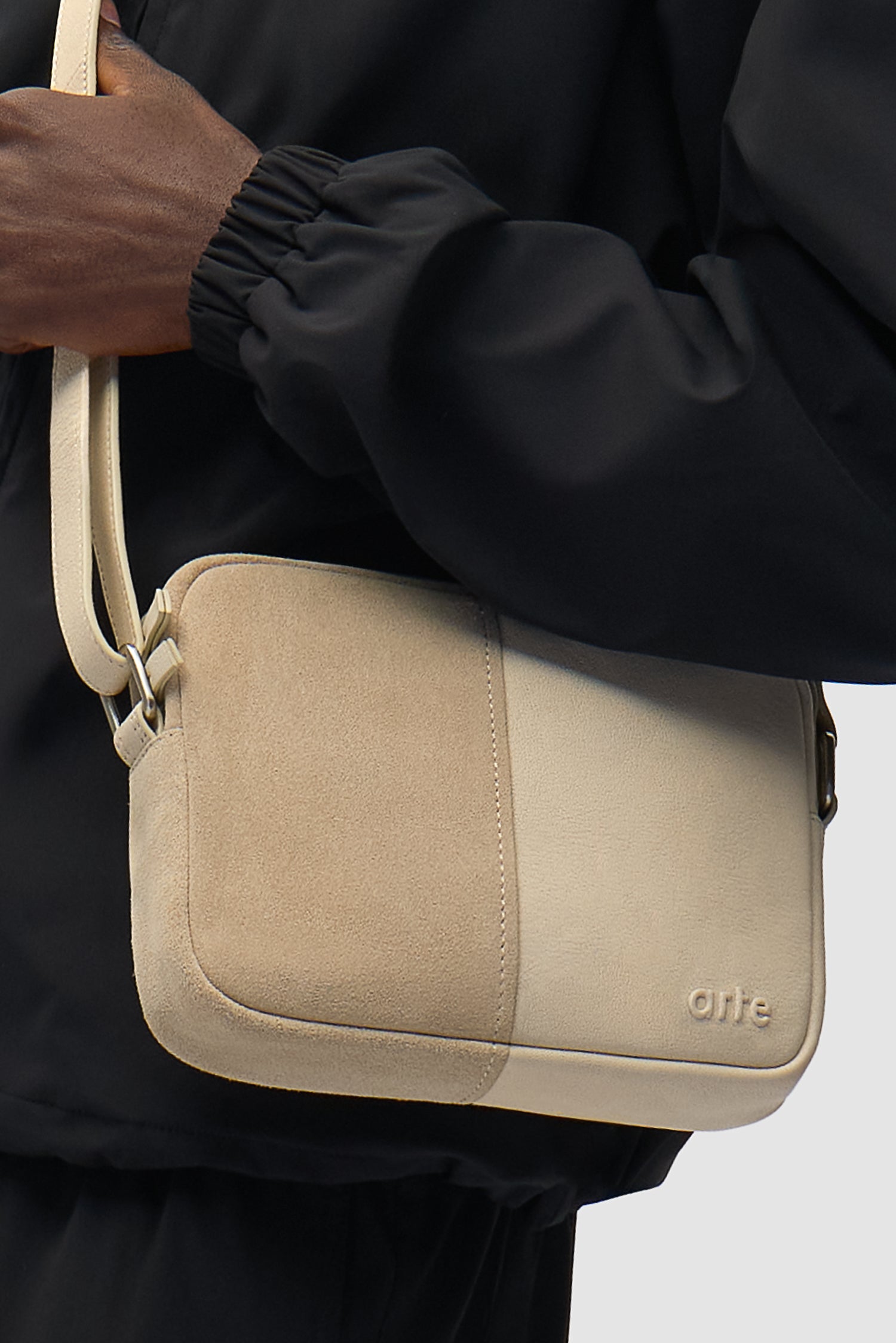 Sac Multi Leather Baka couleur crème porté par un mannequin, vue de demi-corps