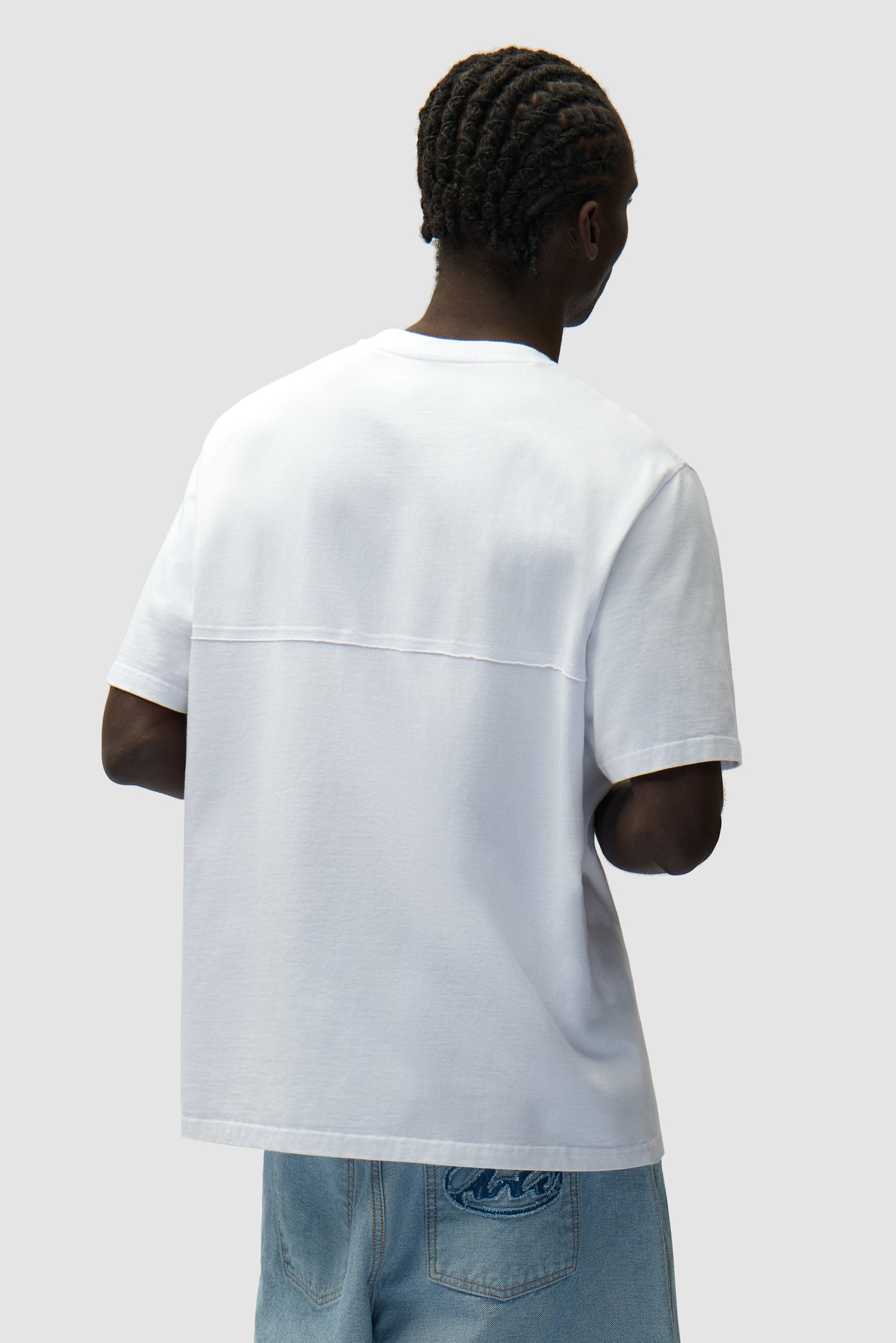 Circle Logo Cut T-shirt in White worn by a model, half-body back view