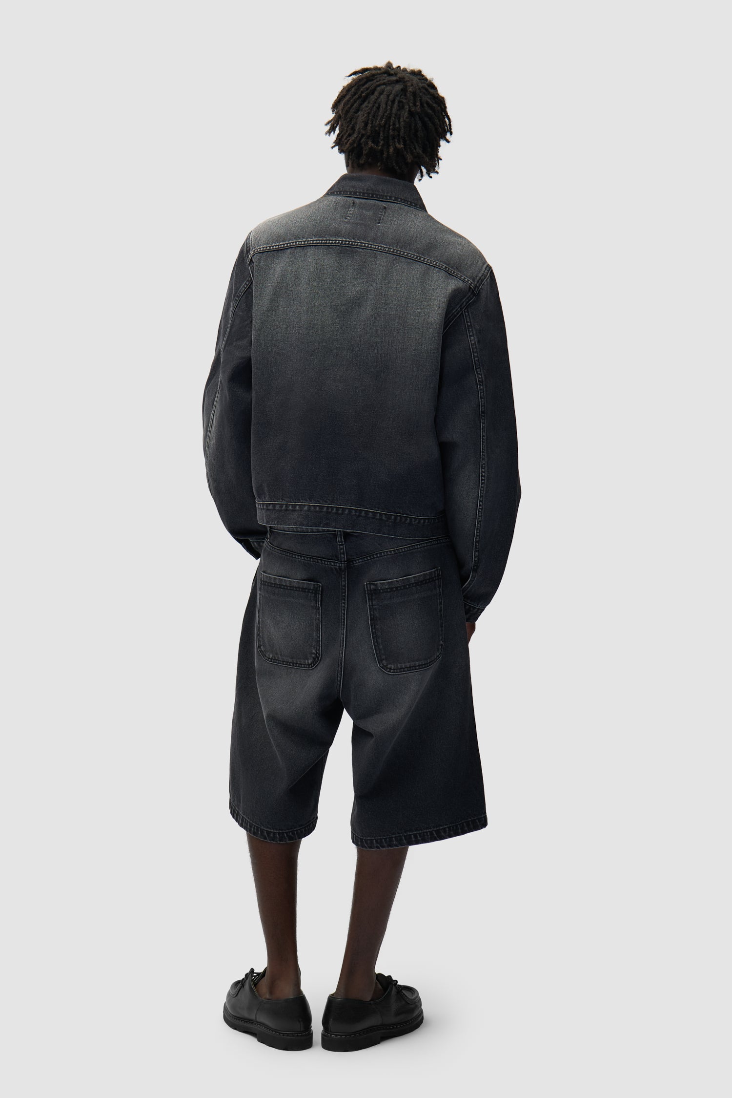 Vue détaillée du short en denim à poches rondes, couleur noir délavé, avec logo