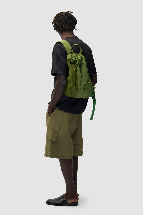 Drawstring Nylon Backpack in Green worn by a model, half-body view