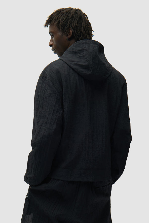 Mesh Jacket in Black worn by a model, half-body back view
