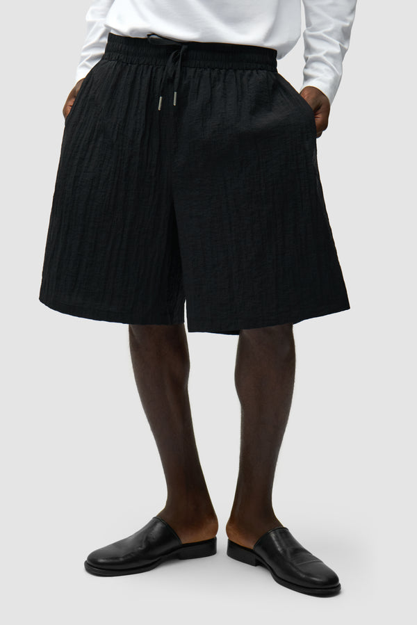 Mesh Shorts in Black worn by a model, half-body front view