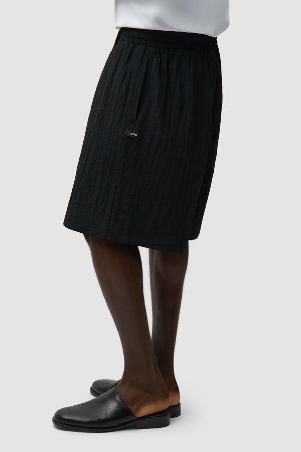 Mesh Shorts in Black worn by a model, half-body side view