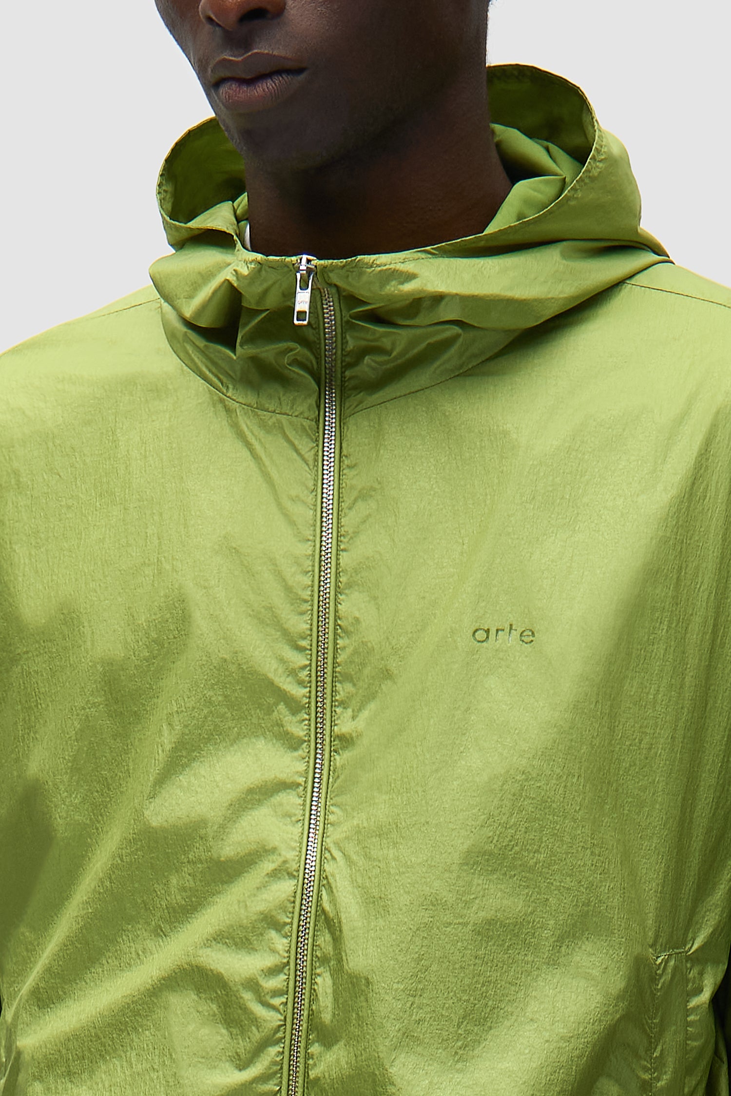 Detail view of Shiny Nylon Jacket in Green, showing front zipper