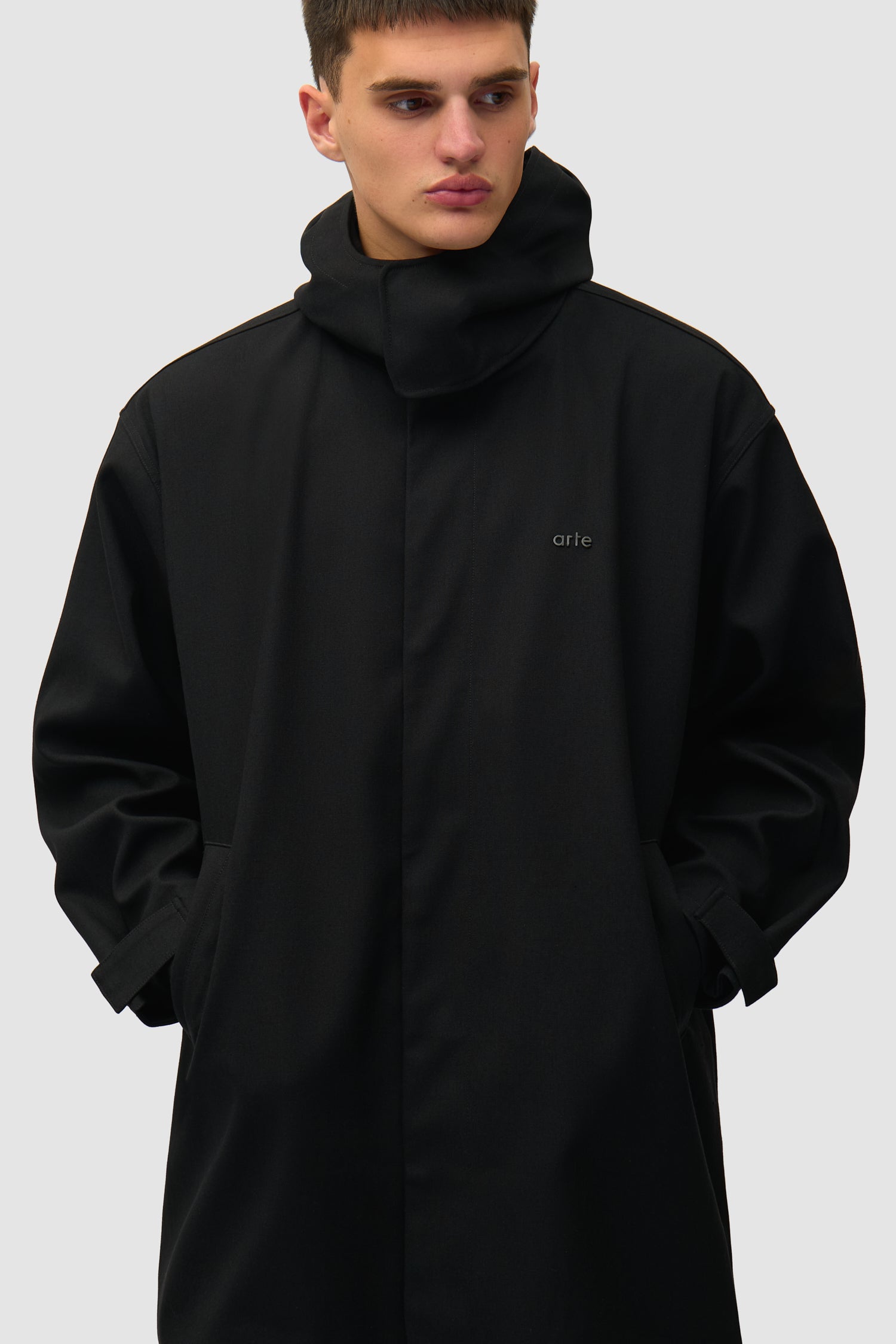 Manteau en lin noir porté par un mannequin, vue de profil à mi-corps