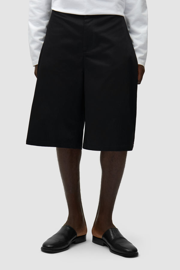 Classic Shorts in Black worn by a model, half-body front view