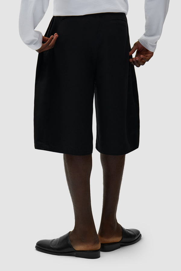 Classic Shorts in Black worn by a model, half-body back view