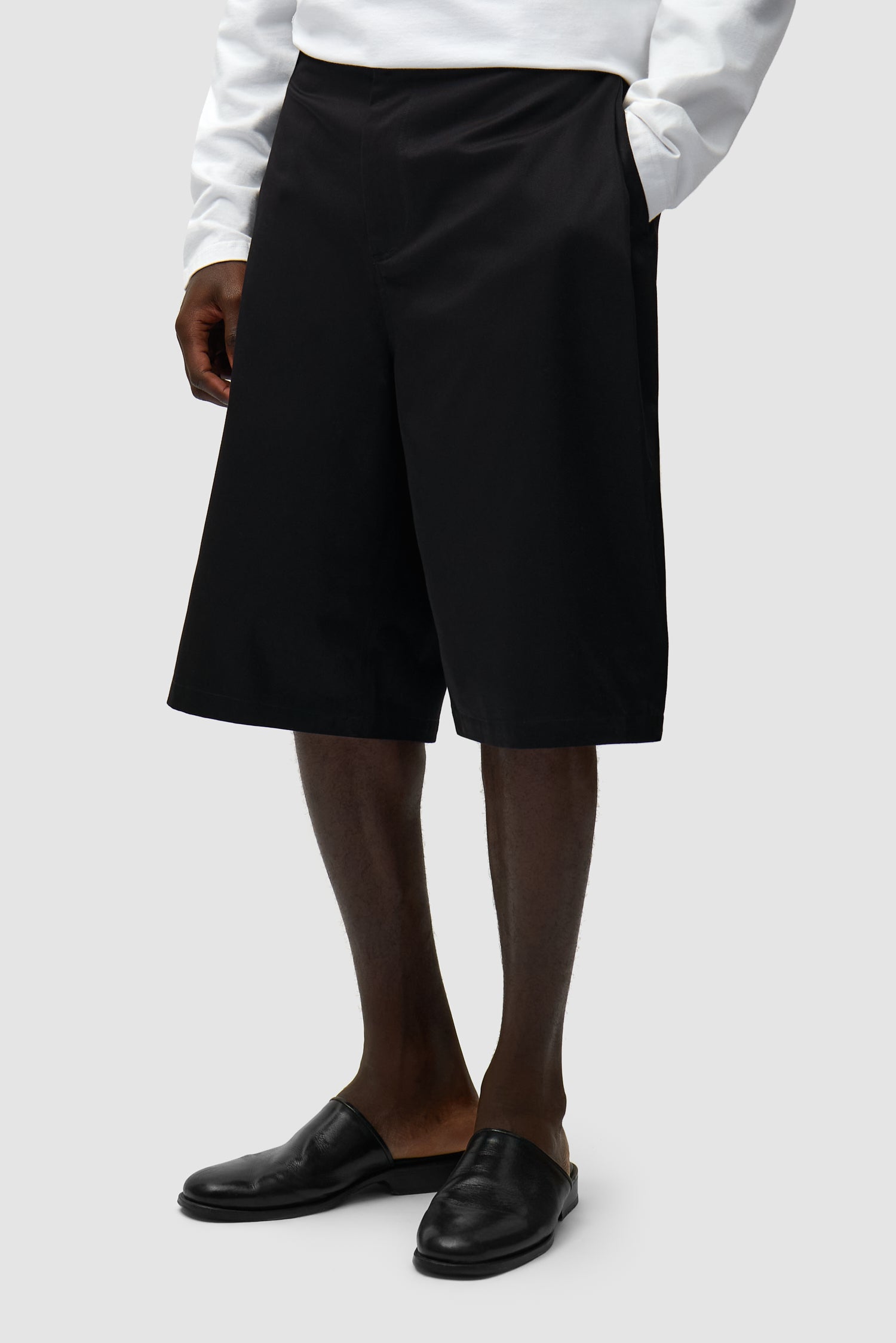 Classic Shorts in Black worn by a model, half-body side view