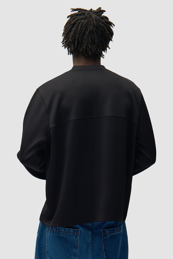 Circle Logo Longsleeve in Black worn by a model, half-body back view