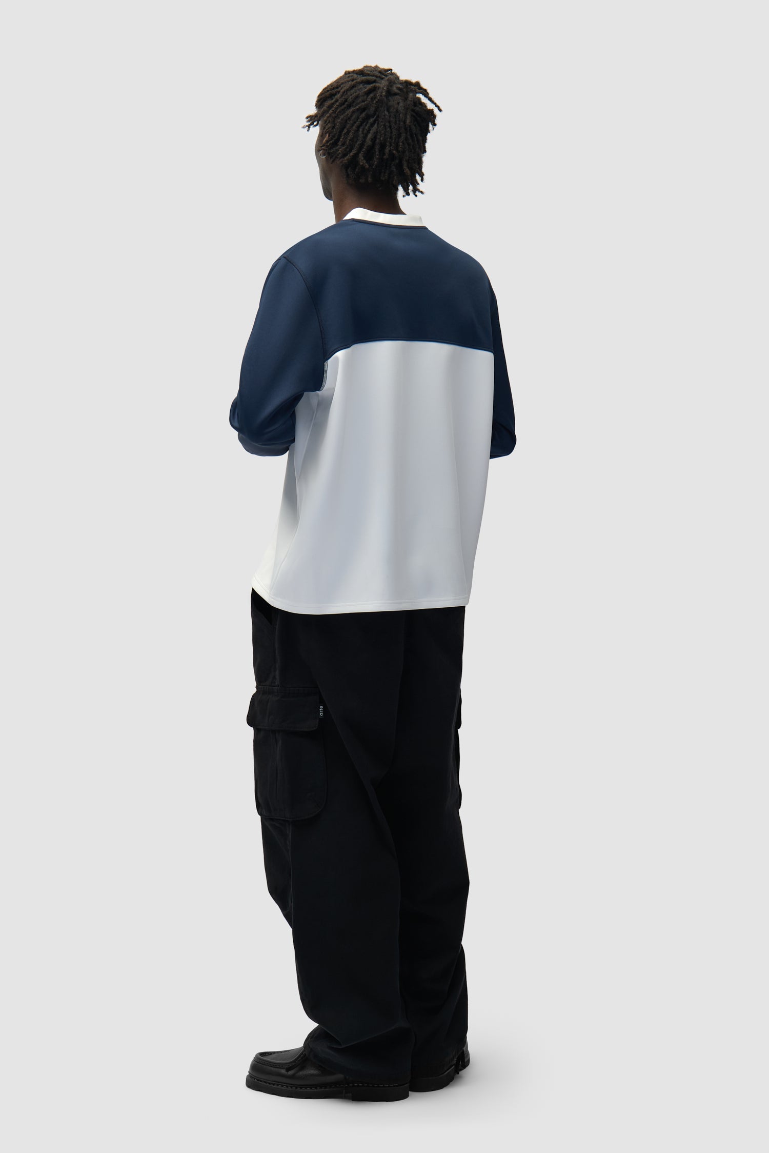 T-shirt à manches longues avec logo circulaire blanc/bleu marine porté par un mannequin, vue arrière en pied